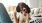 woman lies on a couch and pets her dog
