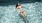 woman floats on her back in swimming pool